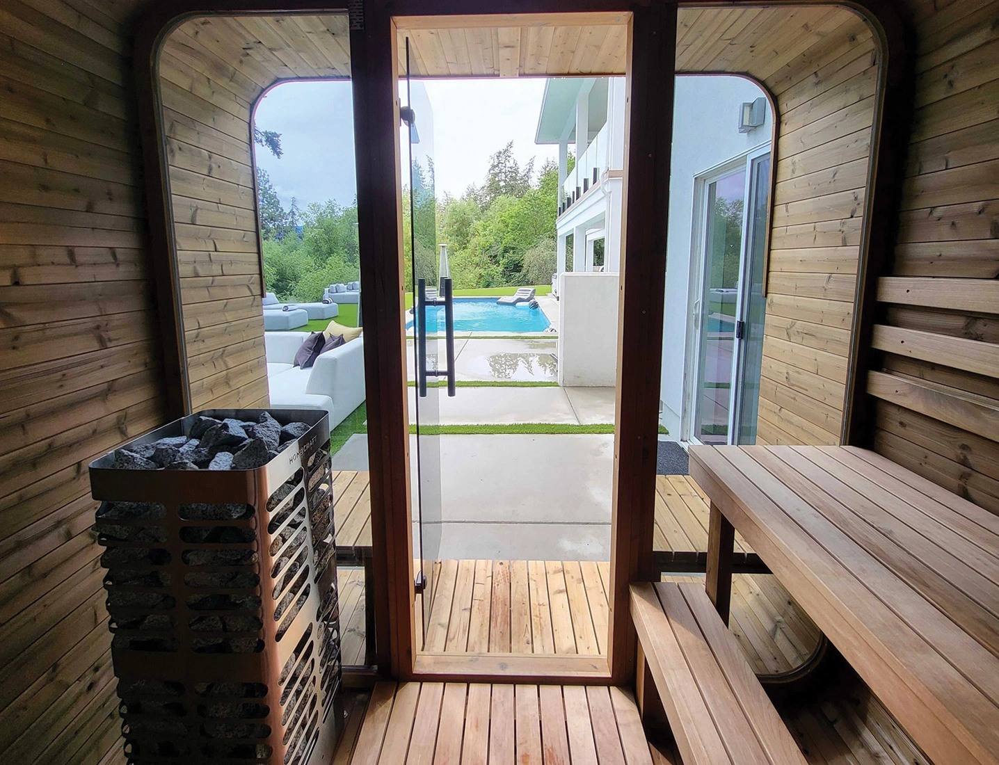 inside looking out door and windows of square sauna with homecraft heater