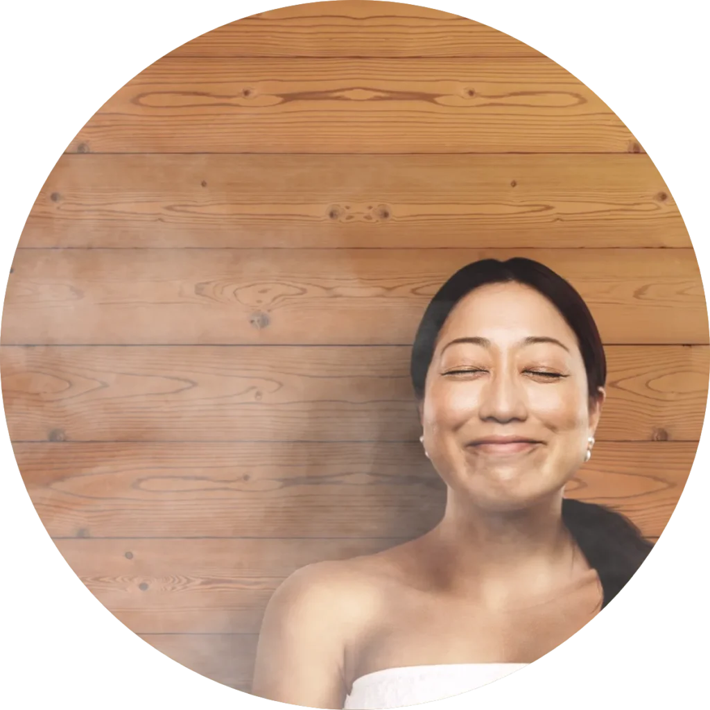 Smiling and relaxing woman sitting in a sauna